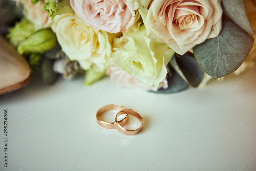 wedding rings lie on the table near a wedding bouquet wedding rings lie on the table near a wedding bouquet