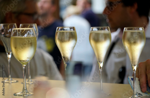 Closeup of glasses filled with prosecco with blured people in the background