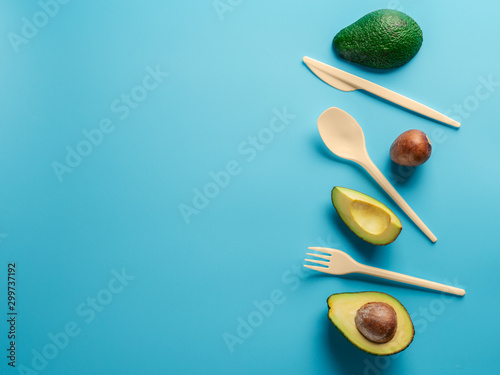 Avocado Seeds Biodegradable Single-Use Cutlery. Bioplastic - Great alternative to plastic disposable cutlery. Minimal concept on blue background. Copy space for text or design photo