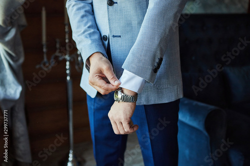 Businessman wears a jacket,male hands closeup,groom getting ready in the morning before wedding ceremony