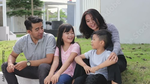 beautiful happy asian family in front of their house having fun and smiling