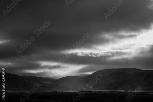 Sunlight penetrates through the clouds and illuminates a rain shower over the Svinadalur at Búðardalur in western Iceland.