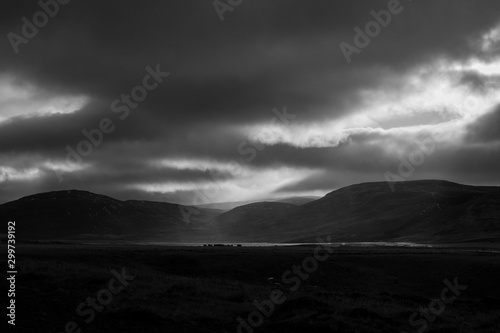 Sunlight penetrates through the clouds and illuminates a rain shower over the Svinadalur at Búðardalur in western Iceland.