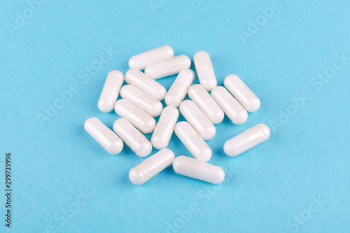 food supplement capsules on blue background closeup