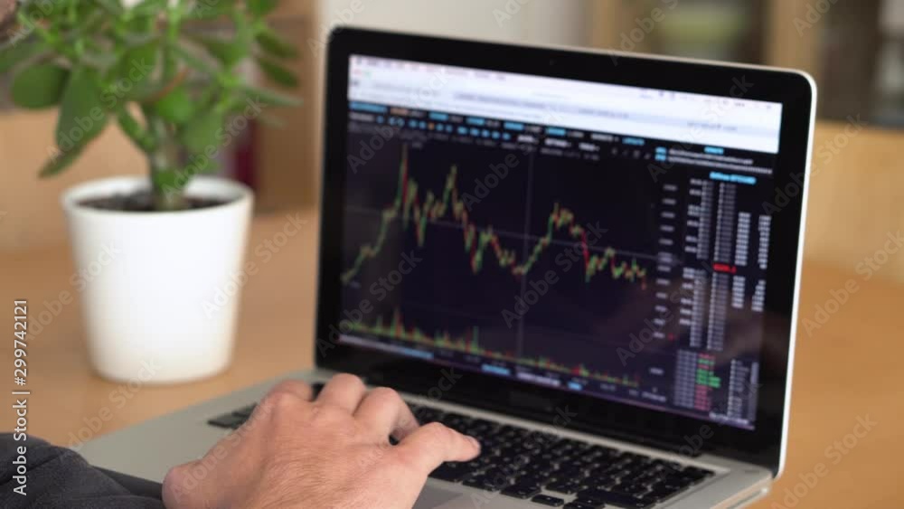 4k resoltuion of man working on a laptop, with financial charts displayed. Businesss man at a computer, indoors shot. 4k resoltuion of man working on a laptop, with financial charts displayed. Businesss man at a computer, indoors shot.