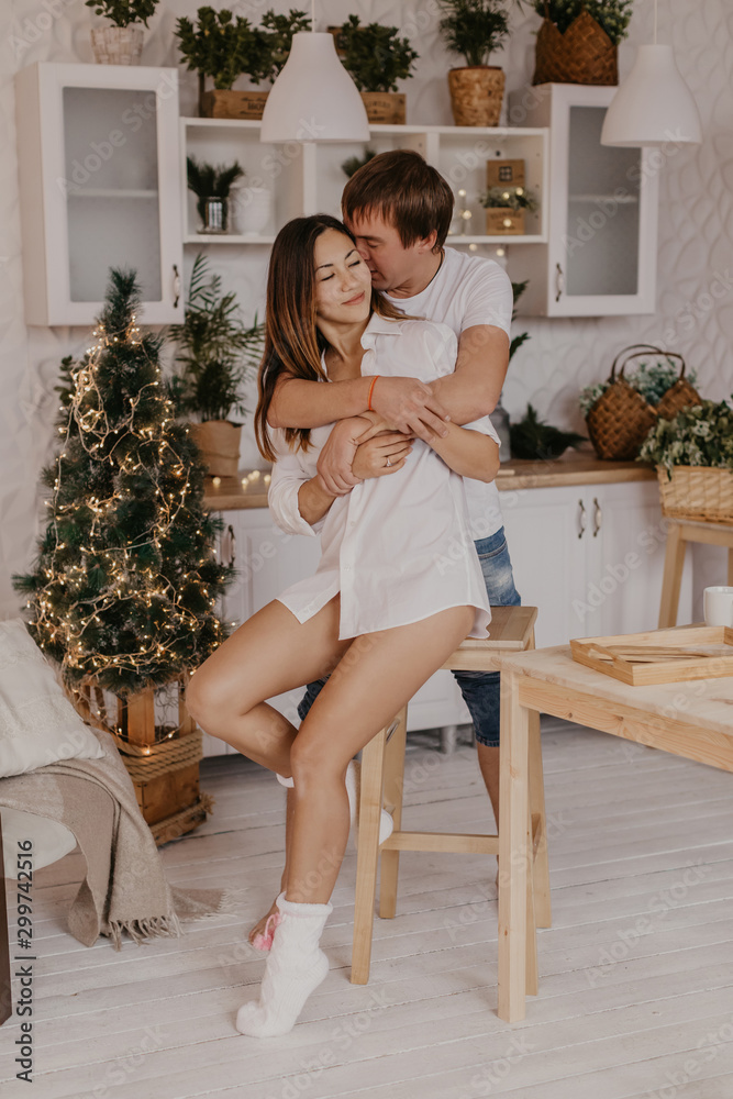 Beautiful couple in love celebreting Christmas. Kitchen breakfast - Image Beautiful couple in love celebreting Christmas. Kitchen breakfast - Image
