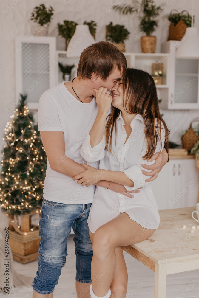 Beautiful couple in love celebreting Christmas. Kitchen breakfast - Image Beautiful couple in love celebreting Christmas. Kitchen breakfast - Image