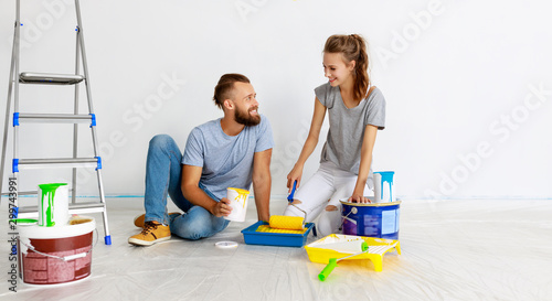 Принти на полотні young happy couple is repairing and painting   wall at home.