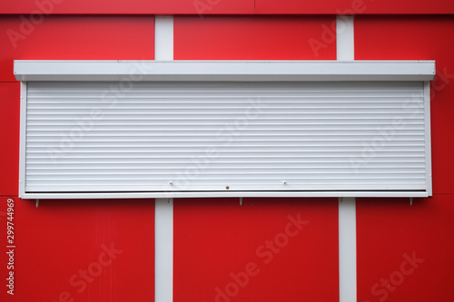 White roller shutters at a red kiosk. Street retail, shop, market. Modern safety and security.