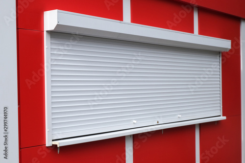 White roller shutters at a red kiosk. Street retail, shop, market. Modern safety and security.