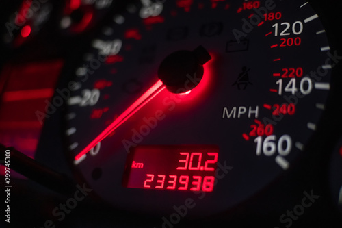 car dashboard. Speedometer with red backlight at night close up photo