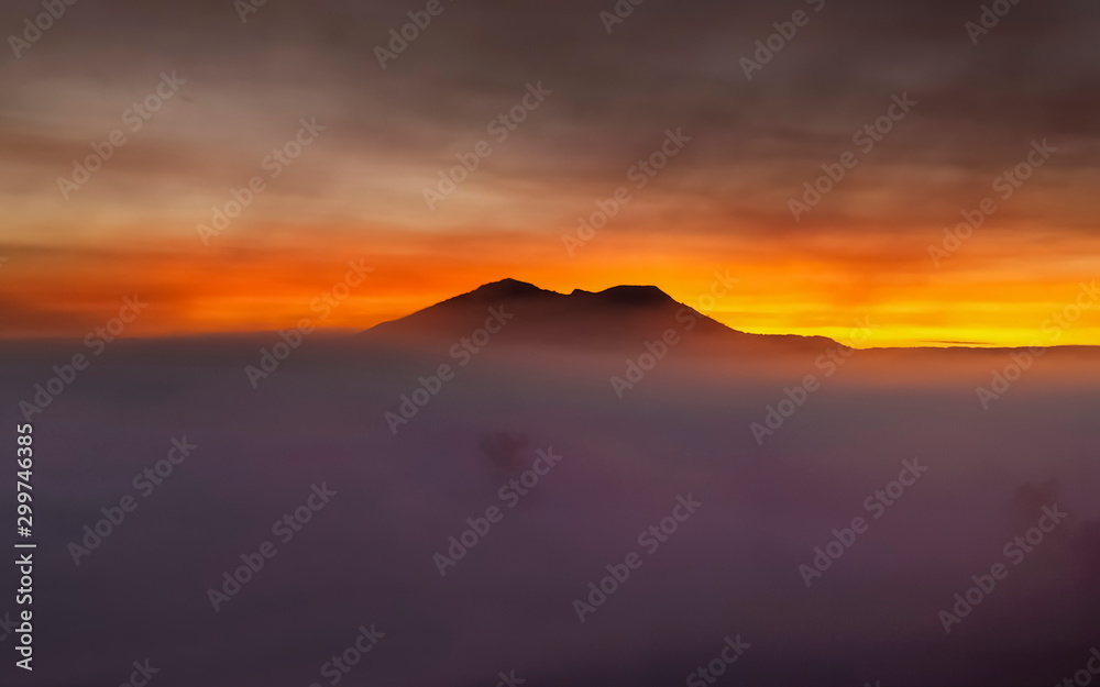 view morning of Peak mountain around with sea of fog with red sun light in cloudy sky background, sunrise at Thung Salang Luang, Khao Kho, Phetchabun, Thailand.