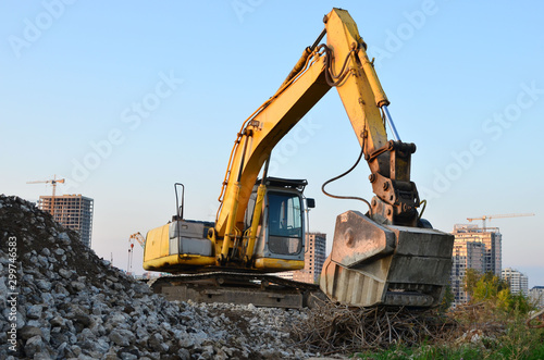 Excavator with crusher bucket for crushing concrete. Construction waste recycling for construction mix. Sifting and grinding bucket for the separation of concrete into fractions of higher quality.