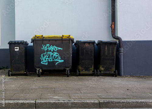 black plastic trash containers street by day closeup © Mykola