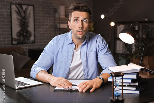 Stressed man trying to meet deadline in office