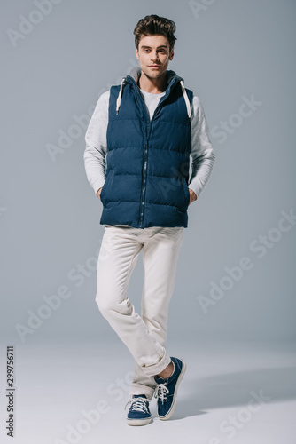 Fotografija handsome fashionable man posing in waistcoat on grey