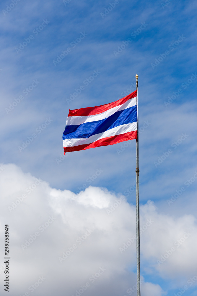 Image of waving Thai flag of Thailand with blue sky background.