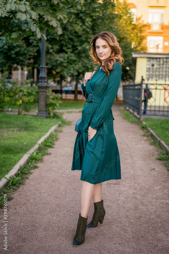 beautiful young woman on a walk in a green dress.