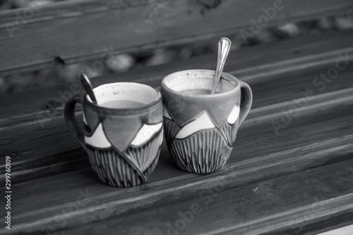 two coffee cups on wet wooden surface  morning rainy autumn