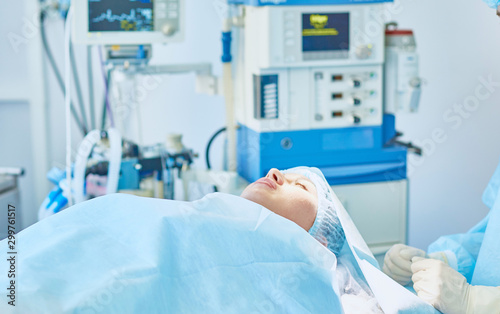 Several doctors surrounding patient on operation table during their work. Team surgeons at work in operating room