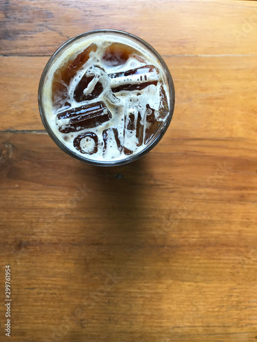 iced coffee with creama foam in round glass on wood table photo