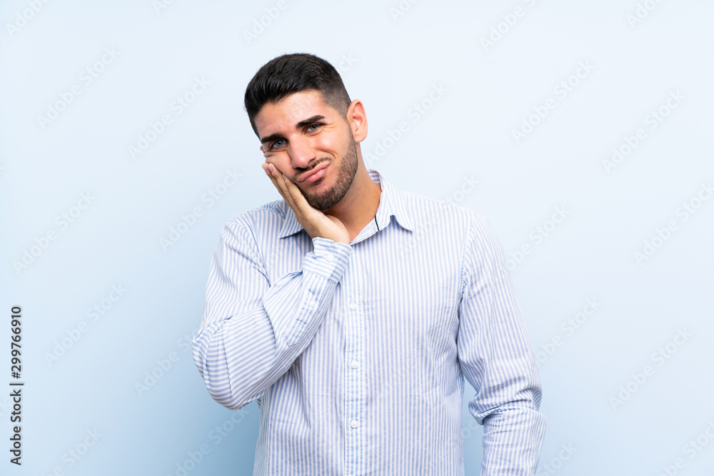 Caucasian handsome man over isolated blue background unhappy and frustrated