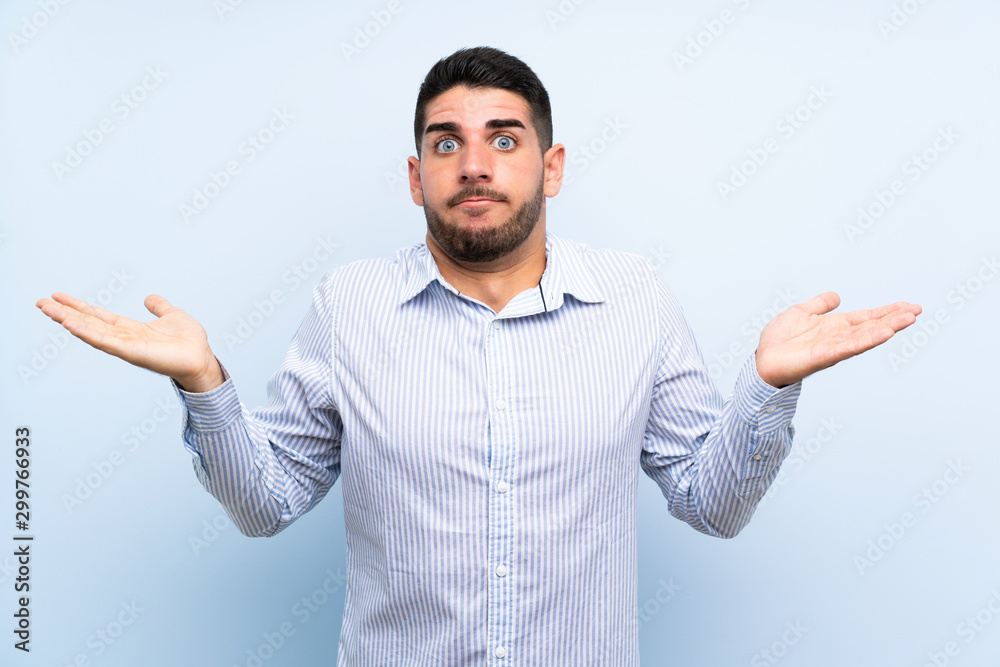 Caucasian handsome man over isolated blue background having doubts with confuse face expression Caucasian handsome man over isolated blue background having doubts with confuse face expression
