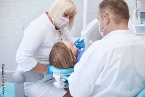 Doctor dentist treats teeth of a beautiful young girl patient. The girl on reception at the dentist. Doctor dentist treats tooth