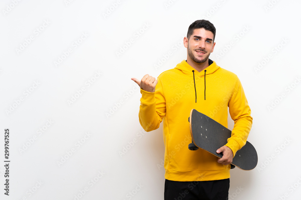 Handsome young skater man over isolated white wall pointing to the side to present a product Handsome young skater man over isolated white wall pointing to the side to present a product