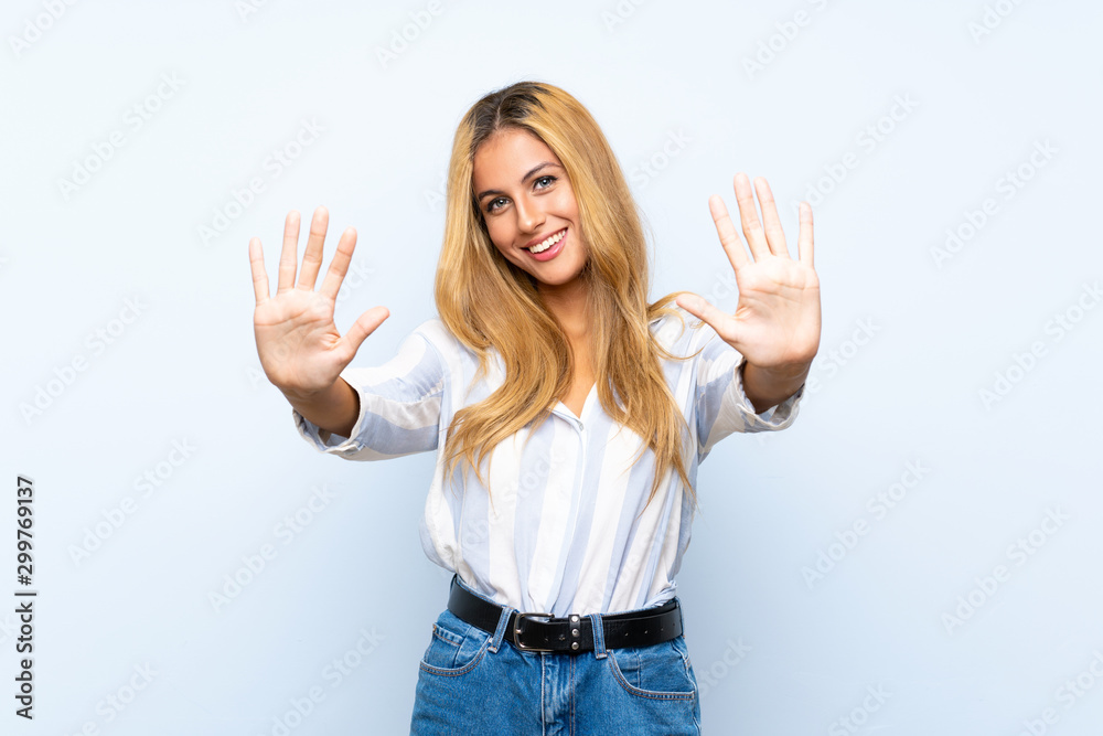 Young blonde woman over isolated blue background counting ten with fingers Young blonde woman over isolated blue background counting ten with fingers