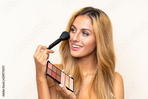Young blonde woman with make-up over isolated background