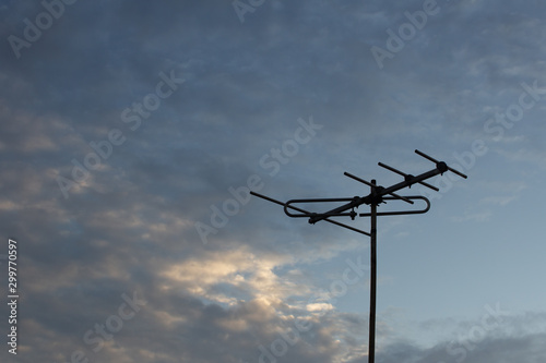 Television antenna on the roof top with evening sky background