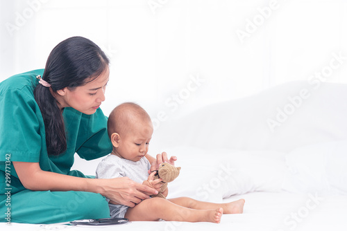 Pediatrician doctor prepare for examines baby girl with stethoscope checking heart beat.