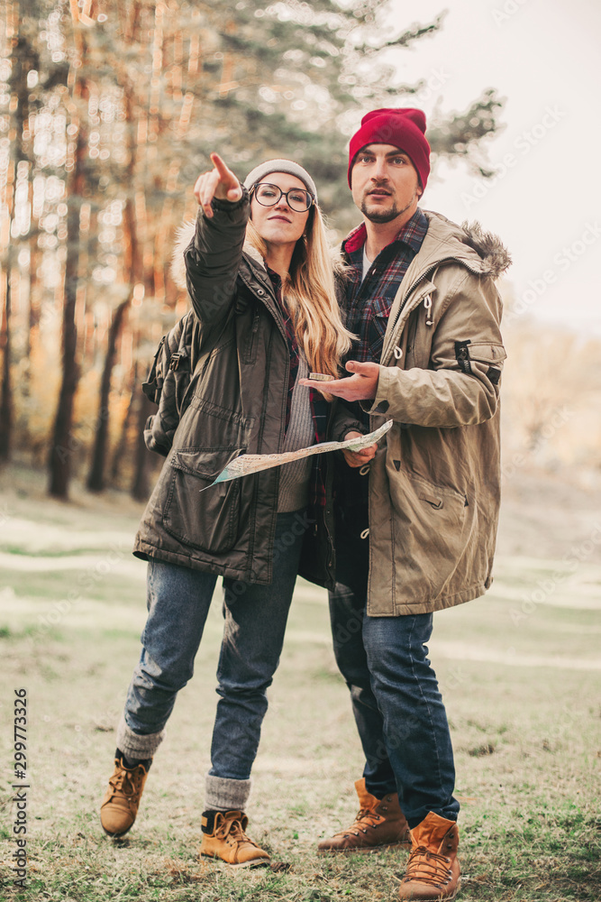Travel couple with map, compass and backpack in the forest. Freedom and active travel concept. Travel couple with map, compass and backpack in the forest. Freedom and active travel concept.