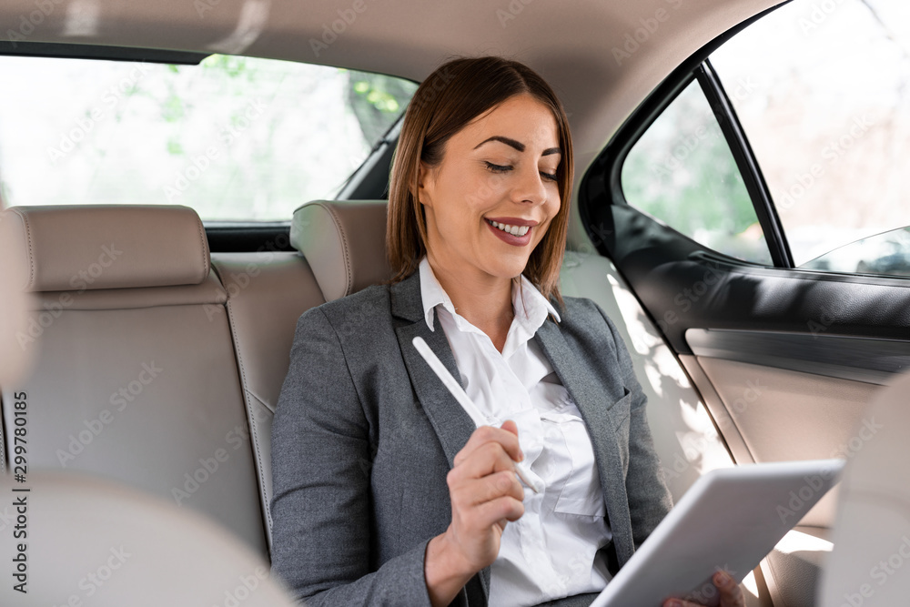 Beautiful young business woman is driving in the car to work