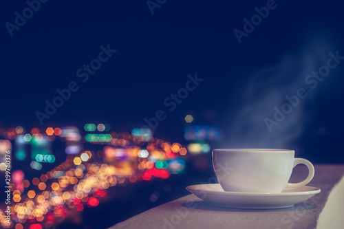 Wallpaper Mural White coffee cup and softy stream smoke put on sky terrace border with blurred twilight high angle view of city scape and colorful traffic lighting on road. Selective focus and copy space Torontodigital.ca