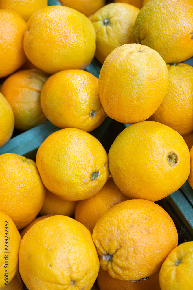 Bright yellow fresh oranges in plastic boxes at farmer's market or grocery store aerial view. May be used for background. Top view. Bright yellow fresh oranges in plastic boxes at farmer's market or grocery store aerial view. May be used for background. Top view.