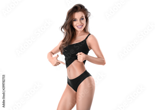 Smiley young woman in black underwear showing by finger on her slim waist.