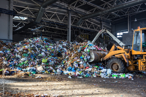 Фототапет excavator stacks trash in big pile at sorting modern waste recycling processing plant