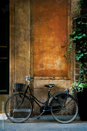 Canvas Print Old bicycle leaning against an old rustic, weathered wall in Rome, Italy