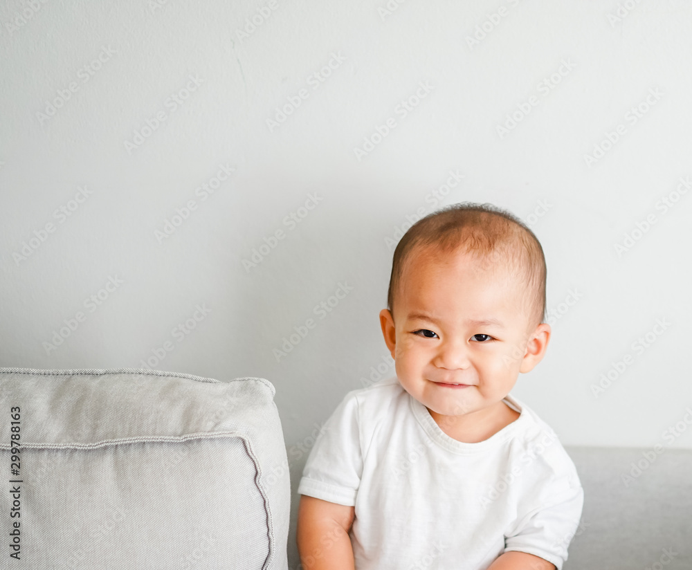 Cute adorable one year seven month old baby boy.Closeup of adorable asian boy child, little baby boy on sofa at home.