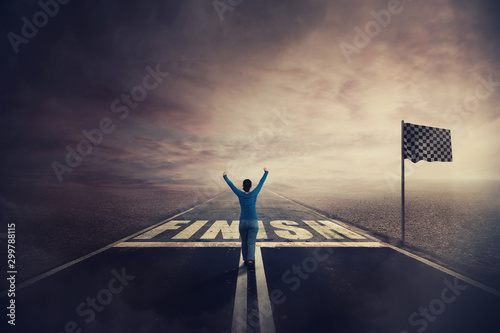 Фотография Competitive young woman on the road celebrate culmination raising hands up crossing the finish line