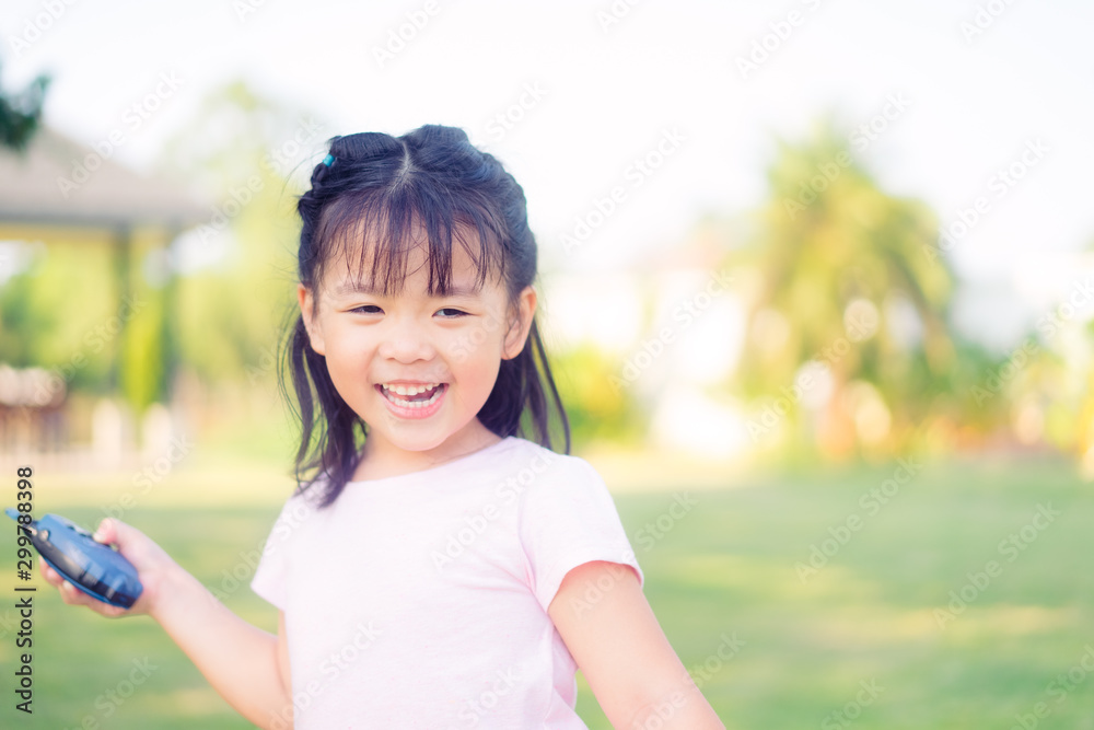 4 years little asian girl playing with walkie-talkie on the park.Happy girl smile and laughing when she plays outside in a playground with a toy walkie talkie radio. 4 years little asian girl playing with walkie-talkie on the park.Happy girl smile and laughing when she plays outside in a playground with a toy walkie talkie radio.