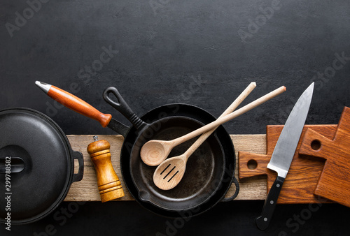 Billede på lærred Kitchen utensils dark background with cast iron black kitchenware