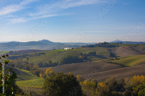 landscape rolling green hills of Italy in October blue bright sky 