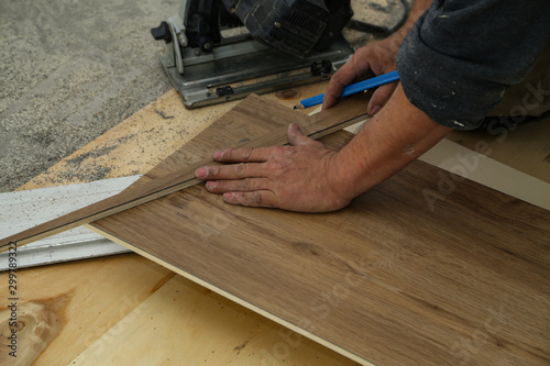 Worker measures and saws off fragments of steps for stairs