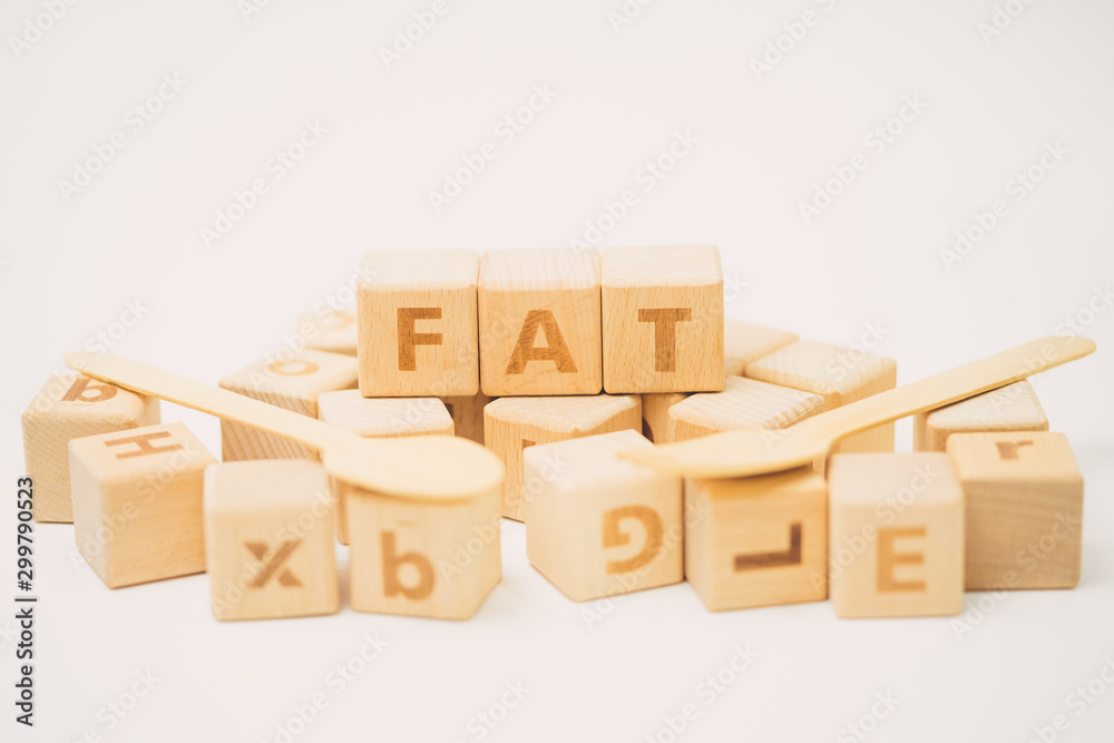 Fototapeta premium FAT word on wooden cube and stethoscope.
