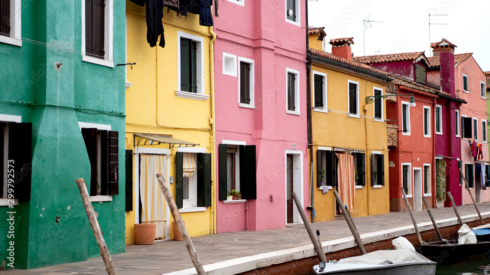 Colorful houses next to a canal in Burano, island next to Venice, Italy. 