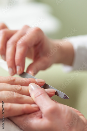 Maniküre einer weiblichen Hand durch eine Kosmetikerin