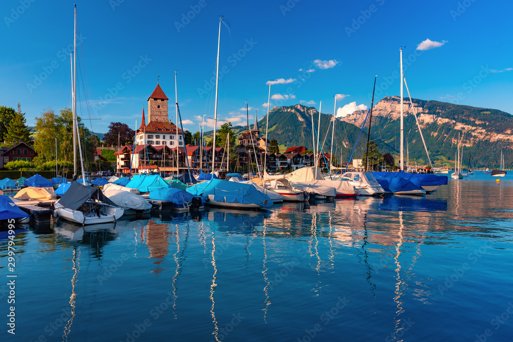 Spiez Church and Castle on the shore of Lake Thun with yachts in the Swiss canton of Bern at sunset, Spiez, Switzerland.
